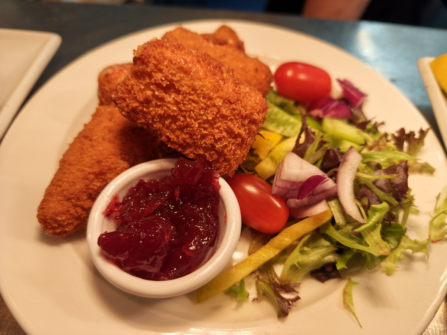 Breaded Brie wedges with salad and chutney